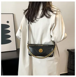 Detail view of black faux leather crossbody bag with chunky gold chain and metal twist lock