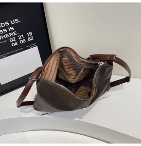 Detail view of deep brown leather tote with striped lining and spacious inner zip pocket