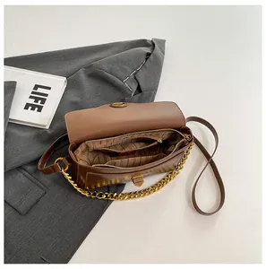Detailed interior of vintage brown leather underarm bag with compartments and gold chain