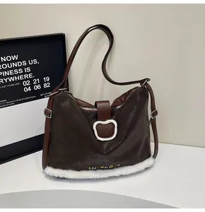 Close-up of brown suede tote with LUCKY DAY embroidery and cute plush bear detail