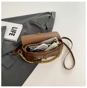 Top view of a brown leather shoulder bag interior showing dual-layer storage with accessories