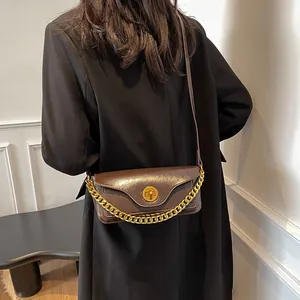 Retro deep brown crossbody bag with gold chain and round clasp shown on black coat