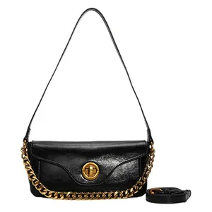 Glossy black underarm bag with gold round buckle and adjustable shoulder strap