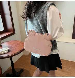 Dettaglio borsa rosa a forma di animale con scritta Princess e borchie in metallo