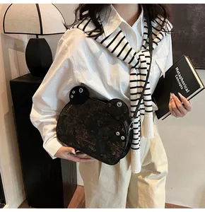 Dettaglio borsa a tracolla nera a forma di rana con trama metallica e scritta Princess