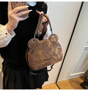 Dettaglio della borsa a tracolla vintage a forma di orso marrone con ricamo Princess e pelle