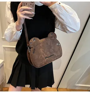 Dettaglio della borsa a tracolla vintage marrone a forma di animale con ricamo e occhielli