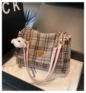 Detail of plaid tweed tote bag with gold hardware, leather strap and cute dog charm