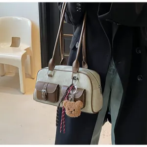 Close-up of vintage Boston bag with leather trim and brown teddy bear charm accessory