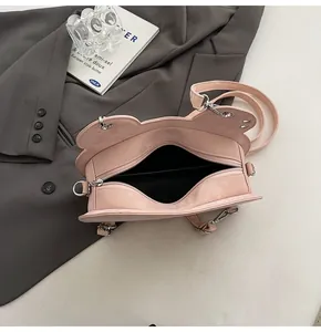 Vista dall'alto della borsa rosa con cerniera, interno nero e ganci metallici argentati