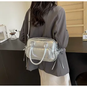 Silver metallic crossbody bag with textured pleats and decorative tassels shown on model