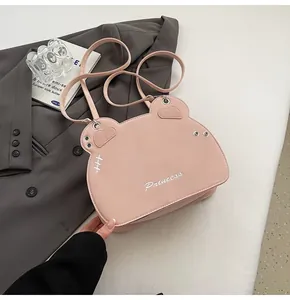 Dettaglio della borsa a tracolla rosa a forma di orso con ricamo Princess e borchie in metallo
