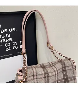 Detail of pink plaid tote bag featuring a leather and gold chain shoulder strap link