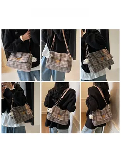 Detail view of plaid tote bag with pink chain strap and metallic triangle logo
