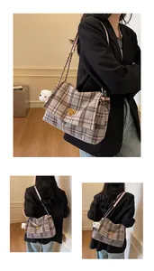 Detail of winter plaid tote bag with gold logo, chain strap and white bear charm