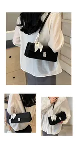 Dettaglio borsa baguette in camoscio nero con fibbia di cristallo e foulard a pois