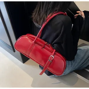 Detail of red glossy leather baguette bag with silver buckle and thin double handles