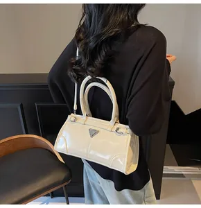 Detail of cream leather handbag with silver triangle logo and side buckle adjustment