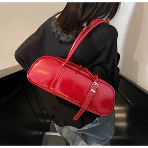Detail view of red glossy baguette shoulder bag with silver buckle and dual zipper