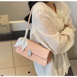 Dettaglio della borsa a spalla in camoscio rosa con fiocco e fibbia di strass