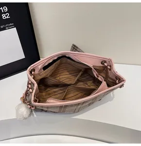 Detail view of large capacity plaid tote with pink leather trim and organized inner pockets