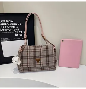 Classic plaid tote bag detail with pink leather chain strap and cute dog charm accent