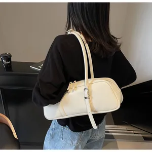 Detail of cream white baguette bag featuring adjustable shoulder straps and smooth leather texture