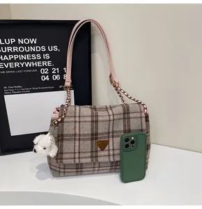 Detail of check tweed shoulder bag with pink leather trim and plush puppy charm
