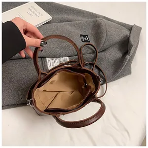Détails du compartiment intérieur spacieux et de la bandoulière en cuir d'un sac seau marron