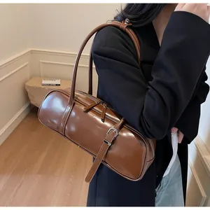 Detailed view of the brown leather boston bag with silver buckle and sleek zipper closure