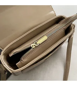 Close-up of the khaki saddle bag interior with a smooth golden metal zipper closure