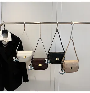 Row of four faux leather saddle bags with crocodile texture and gold horse charms