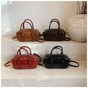 Close-up of retro square crossbody bags in four colors on a minimalist display