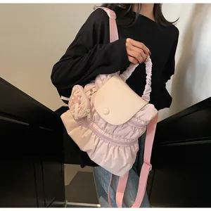 Détail du sac à dos plissé rose clair avec rabat en cuir crème et sangles en tissu