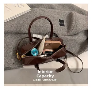Detail showing internal capacity of the dark brown square bag with phone and cosmetics
