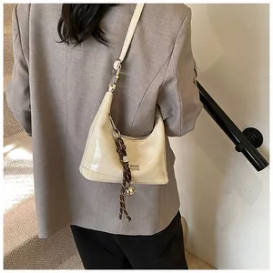 Detail of off-white glossy leather shoulder bag with COIN STUDIO embossed logo