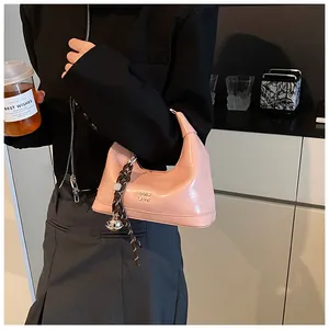 Pink patent leather hobo bag with a decorative woven knot and metallic logo detail