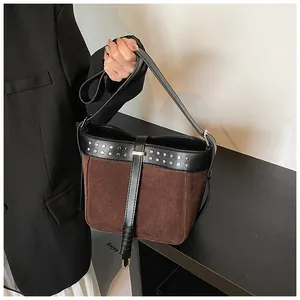 Detail of contrast bucket bag with silver rivets and brown matte suede texture