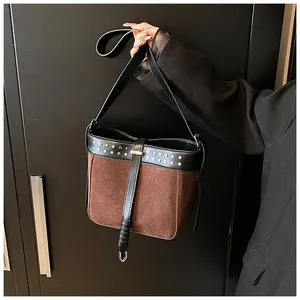 Detail of retro contrast bucket bag with silver metal rivets and wide shoulder strap