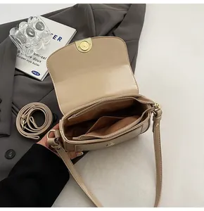 Detailed interior view of beige faux crocodile saddle bag with zip pocket and magnetic closure