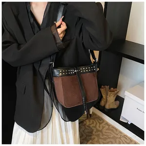 Close-up of contrast bucket bag with silver rivets and smooth black leather details