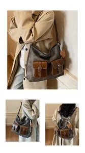 Detail view of large grey canvas tote bag with brown leather pockets and plush bear charm