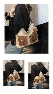Detail of canvas tote bag with brown leather pockets and a small plush bear pendant