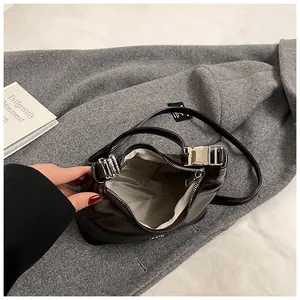 Detail view of glossy brown handbag interior with silver hardware and ripple lining