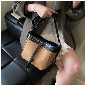 Detail of vintage contrast bucket bag with metallic rivets and brown suede finish