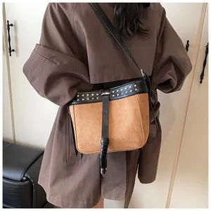 Retro two-tone crossbody bucket bag with silver studs on black shoulder strap