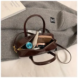 Deep coffee square bag interior showing daily items like phone and cream in detail