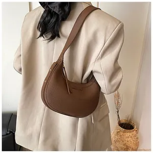 Borsa a mezzaluna marrone in pelle martellata con logo KOSDA portata a spalla