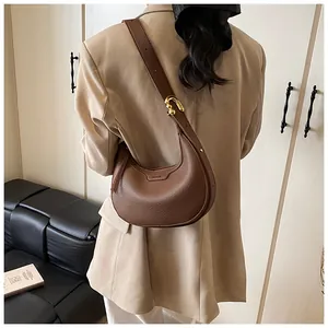 Dettaglio della pelle martellata marrone scuro e fibbia dorata sulla borsa hobo chic