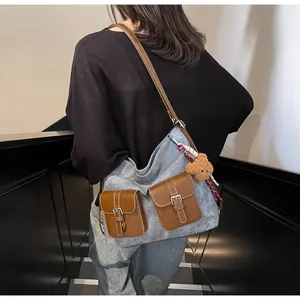 Detail of retro large tote bag with brown faux leather pockets and a plush bear charm